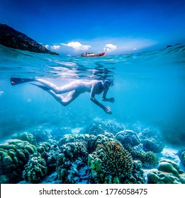 woman snorkeling in clear tropical waters, split image of underwater and longtail boat on surface - active holiday