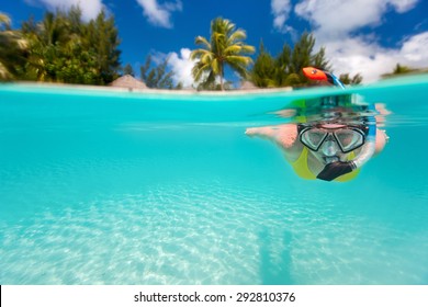 Femme faisant du snorkeling dans des eaux claires et tropicales devant une île exotique