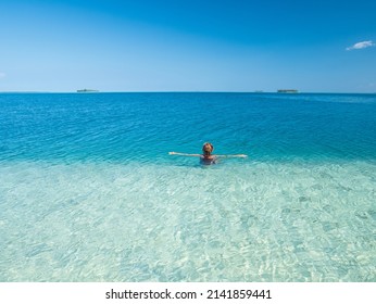 Woman snorkeling on coral reef tropical caribbean sea, turquoise blue water. Indonesia Wakatobi archipelago, marine national park, tourist diving travel destination