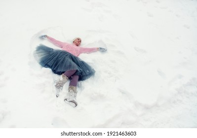 Woman And Snow Angel At Winter Time