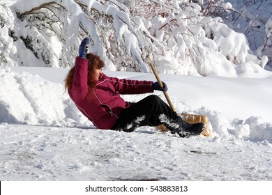 A Woman Is With The Snow Shovel Fallen Down. Wintery Accident