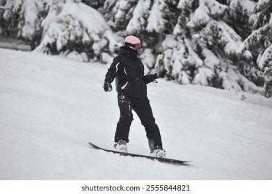 Woman snowboarder ride the slope, downhill. Ski resort, snowboarding, winter sports, snowfall in Dragobrat, Ukraine. Carpathian mountains, foggy day, heavy snow on a trees. Gloomy weather. Cold nature - Powered by Shutterstock