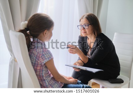 Woman social worker talking to girl. Child psychology, mental health.