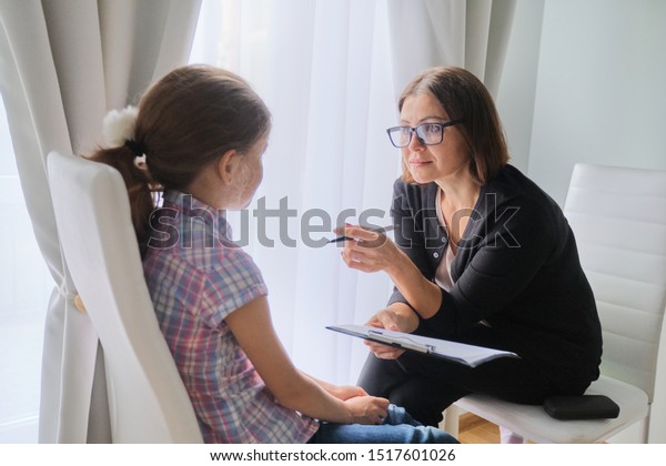 Woman social worker talking to girl. Child\
psychology, mental\
health.