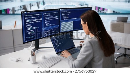 Woman Software Developer Writing Code On Laptop In Contemporary Workspace