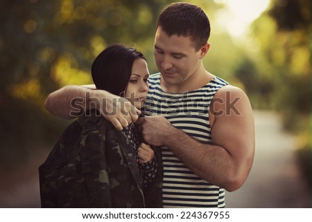 Woman and soldier in a military uniform say goodbye before a separation