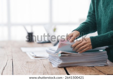 Woman Sorting Through Stack of Documents