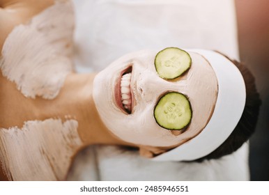 Woman, spa and face mask with cucumber, happy and organic treatment for eye rejuvenation or skin wellness. Pore tightening, beauty facial and client relaxing or skincare, hydration and soothing detox - Powered by Shutterstock