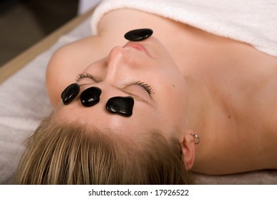 Woman In Spa Receives Hot Stone Facial Treatment. Selective Focus