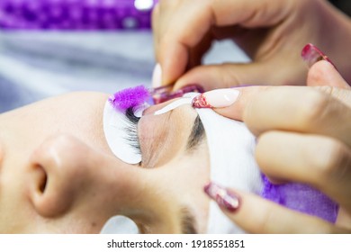 woman at spa salon applying false eyelashes