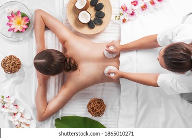 Woman At Spa Thai Massage Tow View, Beauty Treatments Concept. Orchid And Lotus Flowers Coconut Stones And Herb Pouches