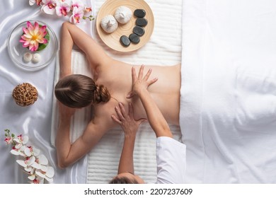 Woman At Spa Thai Massage Tow View, Beauty Treatments Concept. Orchid And Lotus Flowers Coconut Stones And Herb Pouches