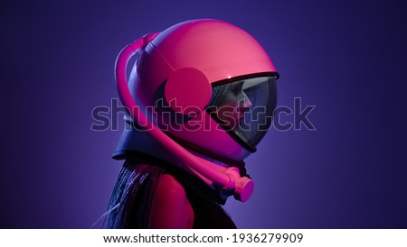 Woman in a space helmet. Multi-colored neon lighting.
