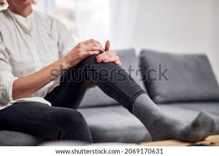 Woman with spasm, cramp, sprained, dislocated knee and joint pain, exercising at home. Stock foto © 