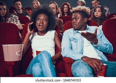 Woman Speaks Loudly On The Phone In The Cinema. The Cinema Hall Is Indignant While The Woman Speaks Loudly On The Phone. 