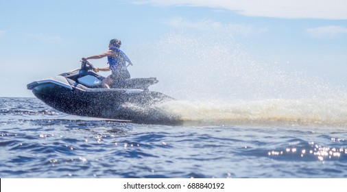 Woman Speeding On Jet Ski On Lake During Summer Vacation