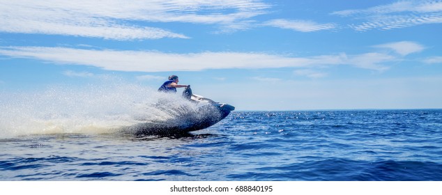 Woman speeding on jet ski on lake during summer vacation