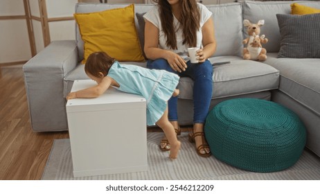 Woman spending time with daughter in cozy living room, toddler climbing onto white table while mother sits on sofa with cup, displaying family bond, home setting, and nurturing care. - Powered by Shutterstock