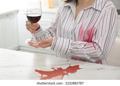 Woman with spilled wine over her shirt and marble table in kitchen, closeup - Shutterstock ID 2232885787