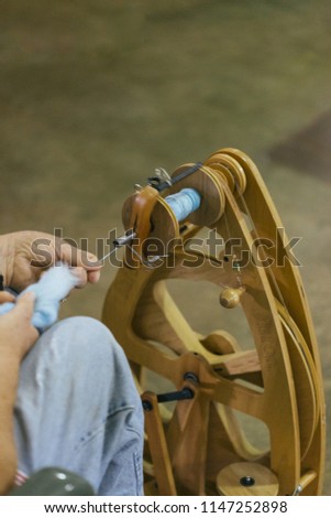 Woman spinning wool onto a spool