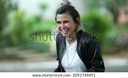 Woman spontaneous real life laugh and smile outside. Person bursts laugh out loud