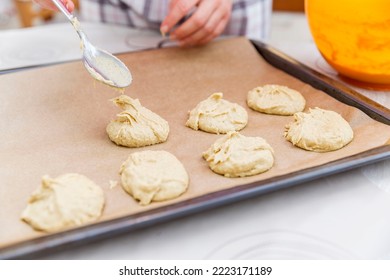 A woman spoons cookie dough onto a baking sheet. Home baking and cooking. Close-up. Selective focus. - Powered by Shutterstock