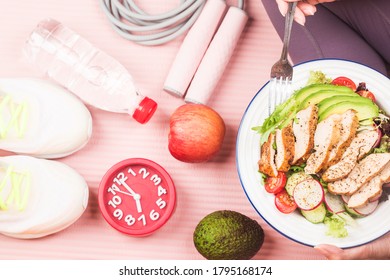 Woman in sport wear holding a dish of fresh salad with , Healthy lifestyle, Woman eating healthy food - Shutterstock ID 1795168174