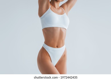 Woman with sportive slim body type in underwear that is in the studio.