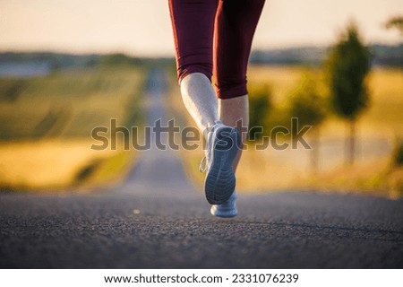 Woman with sports shoe running on road. Outdoor fitness and sports training