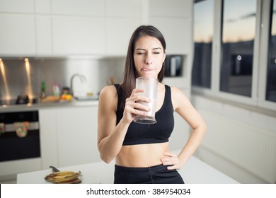 Woman In Sportswear  Drinking Sweet Banana Chocolate Protein Powder Milkshake Smoothie.Drinking Protein After Workout.Whey,banana And Low Fat Milk Sport Nutrition Diet After Gym.Healthy Lifestyle.