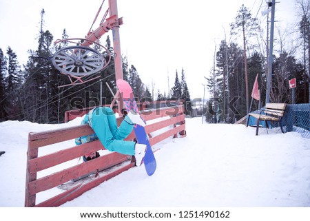 Woman in sportswear posing and fun on background of skiing complex.