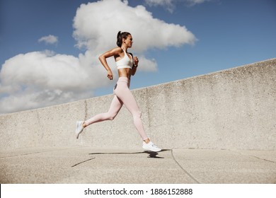 Woman in sportswear running. Woman runner in jogging outfit running outdoors.