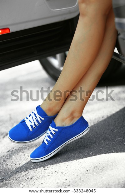 Woman with sporty legs\
in car, close-up