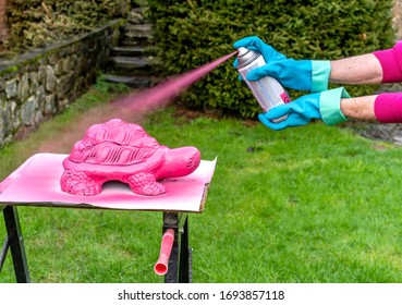 Woman Spray Painting A Homemade Lawn Ornament Shaped Like A Turtle - Spring Is A Good Time To Prepare Outdoor Decorations 