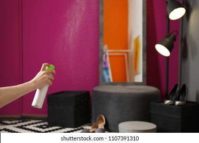 Woman Spraying Air Freshener At Home