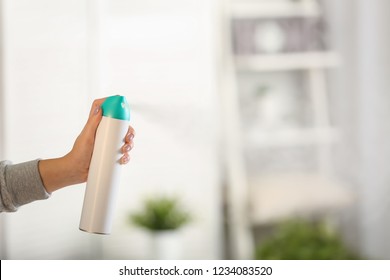 Woman Spraying Air Freshener At Home