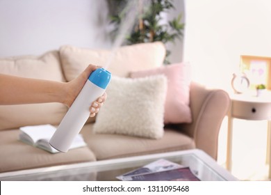 Woman Spraying Air Freshener At Home