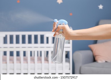 Woman Spraying Air Freshener At Home