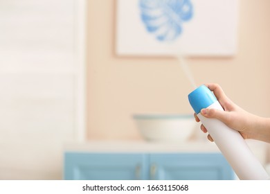 Woman Spraying Air Freshener At Home