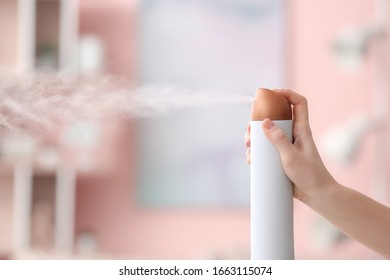 Woman Spraying Air Freshener At Home