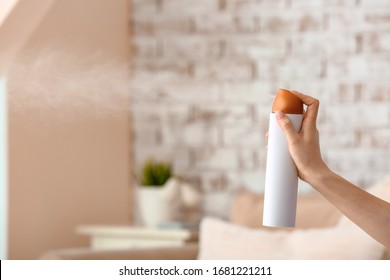 Woman Spraying Air Freshener In Room