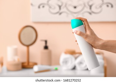 Woman Spraying Air Freshener In Room