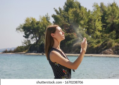 Woman Spraying Facial Mist On Her Face, Summertime Skincare Concept