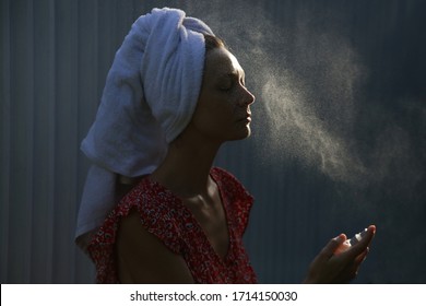 Woman Spraying Facial Mist On Her Face, Summertime Skincare Concept	