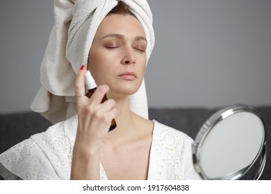 Woman Spraying Facial Mist On Her Face, Summertime Skincare Concept	