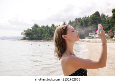 Woman Spraying Facial Mist On Her Face, Summertime Skincare Concept	