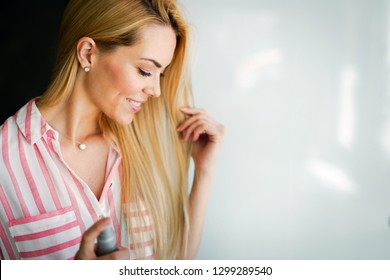 Woman Spraying Hairspray On Beautiful Long Hair