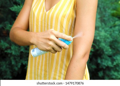 Woman Spraying Insect Repellent On Her Arm Outdoor In Nature Using Spray Bottle. Mosquito Repellent. Bug Spray Anti Insects.