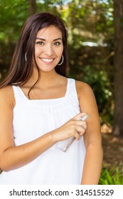 A Woman Spraying Insect Spray On Her Arm