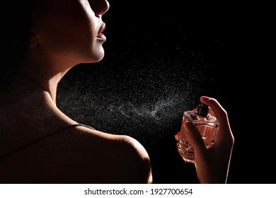 Woman Spraying Luxury Perfume On Black Background, Closeup